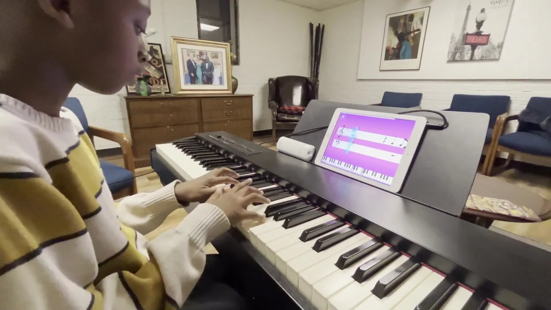 Student practicing piano with digital learning tools